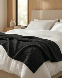 Muslin Blanket in Black in a bedroom