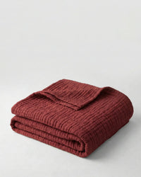Muslin Blanket in Wine Red draped over a bed