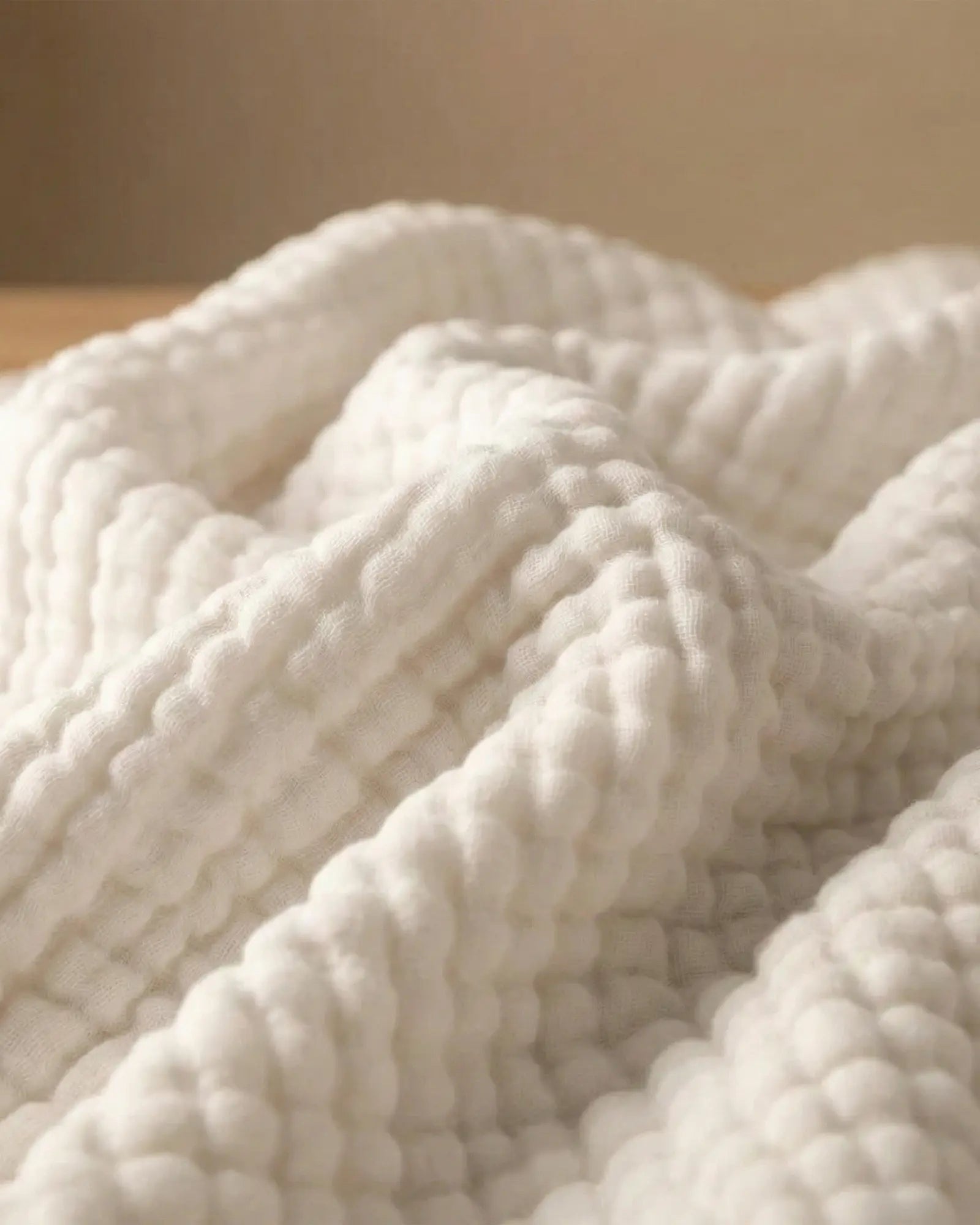 Muslin Blanket in White in a bedroom